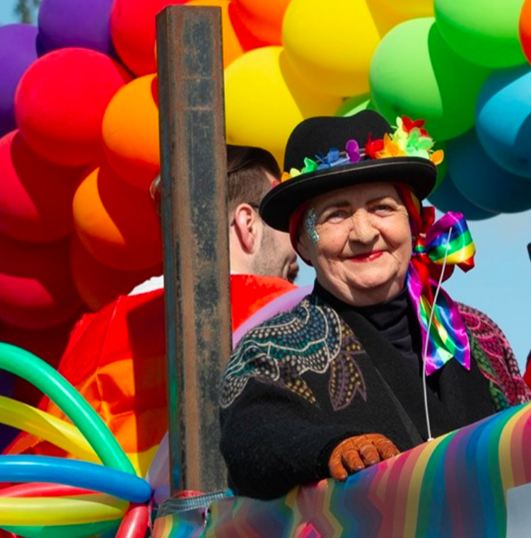 A person with a hat in front of balloons