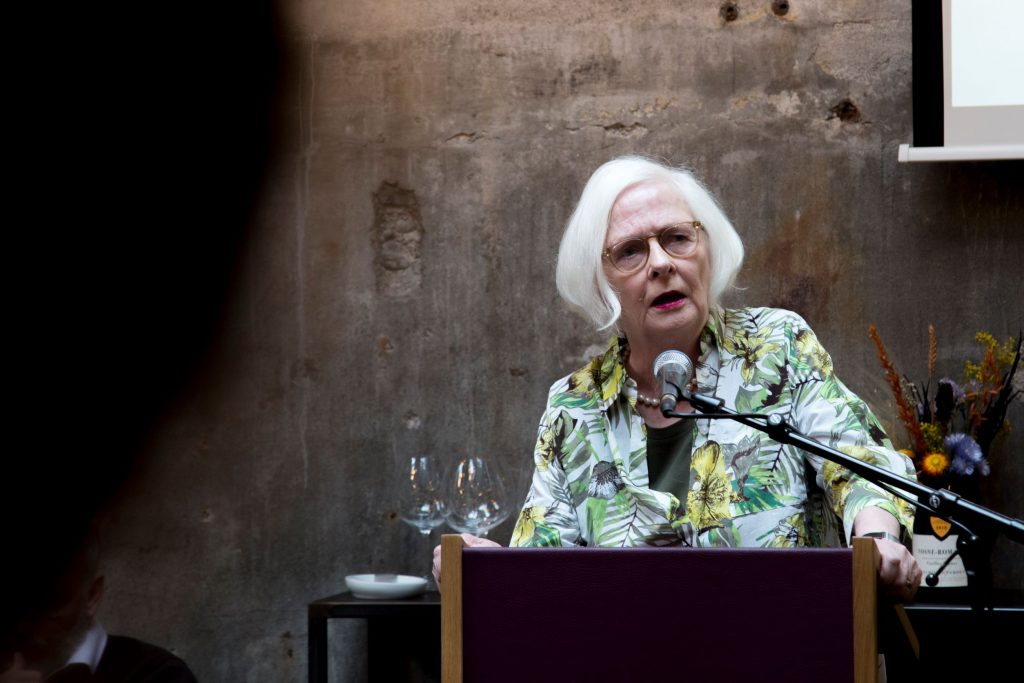 A white haired person in a podium